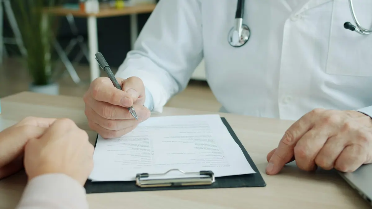 Médico oncólogo registrando la historia clínica del paciente en consulta
